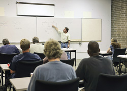Image of adults in a classroom and someone presenting